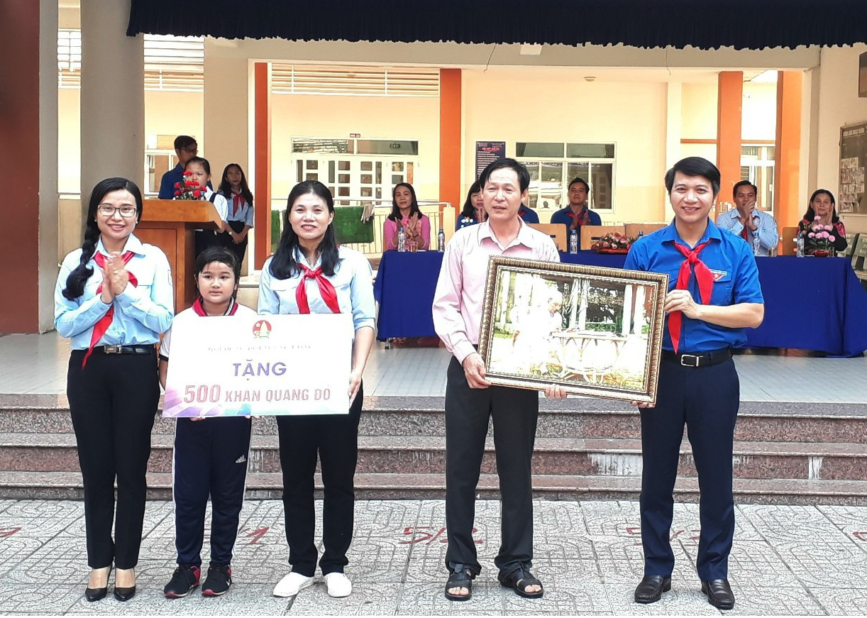 Trao tặng bức tranh “Bác Hồ với thiếu nhi” cho Ban Giám hiệu nhà trường và 500 chiếc khăn quàng cho Liên đội Tiểu học Hòa Phú
